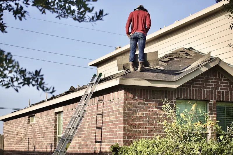 Professional roofer working on a residential roof in Arcade